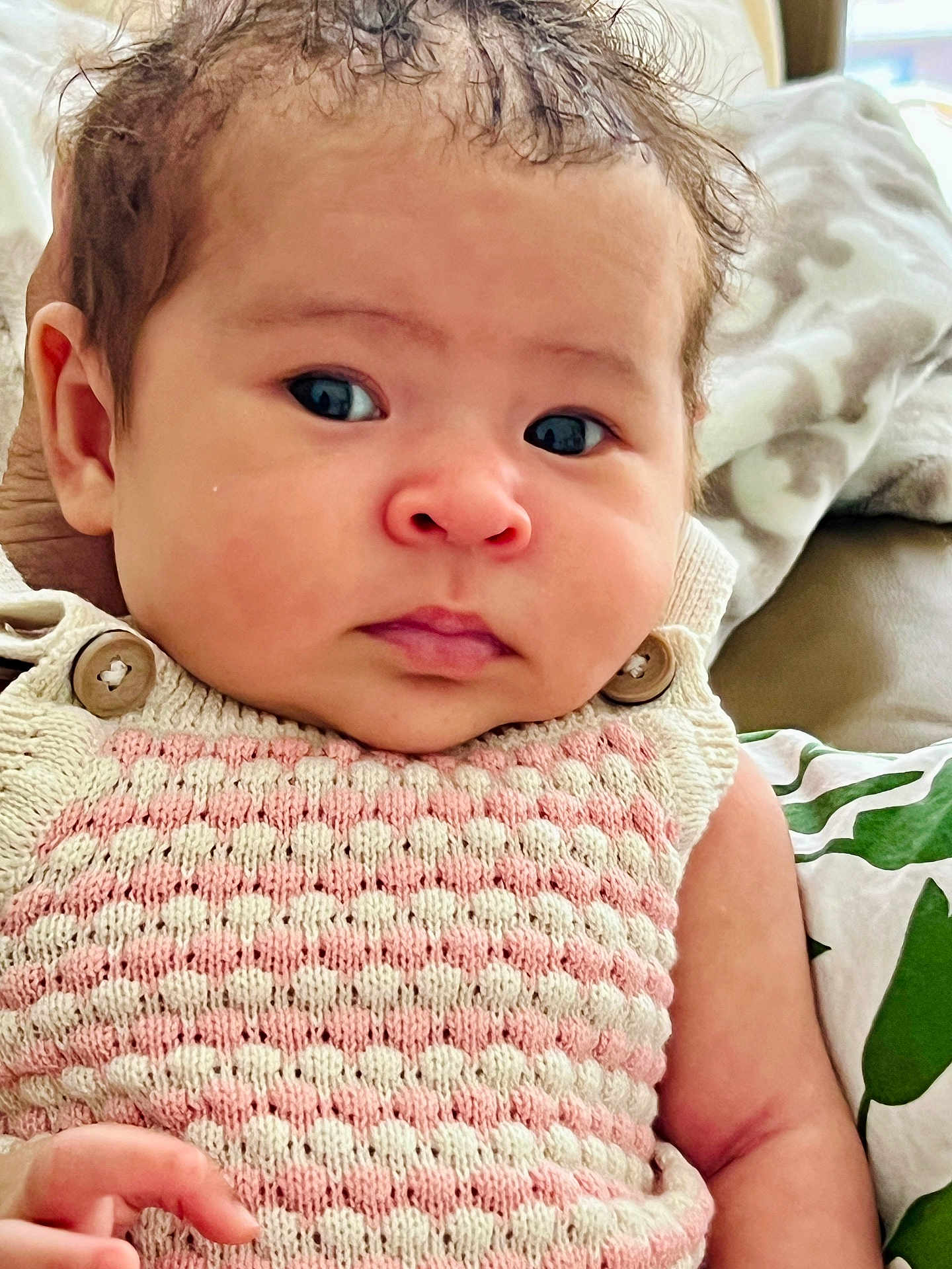 Violet is registered to the contest to win money with this photo: baby, infant, face, eyes, knitwear, clothing, hand, blanket, pillow, pattern, indoor, portrait, cute, child, person, skin, furniture, soft, texture, newborn