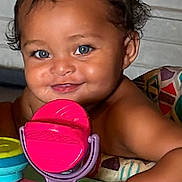 Zaybre is registered to the contest to win money with this photo: baby, child, smile, blue_eyes, curly_hair, toy, colorful, indoor, playtime, diaper, cute, portrait, happy, infant, face, skin, arm, sitting, closeup, play