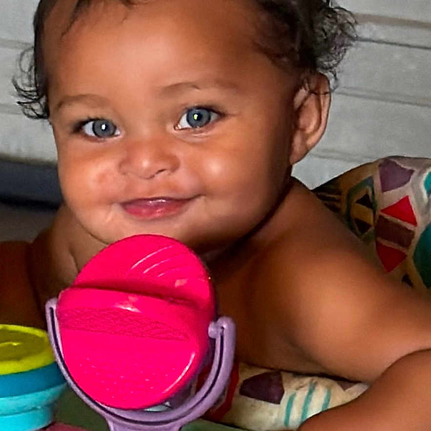 Zaybre is registered to the contest to win money with this photo: baby, child, smile, blue_eyes, curly_hair, toy, colorful, indoor, playtime, diaper, cute, portrait, happy, infant, face, skin, arm, sitting, closeup, play