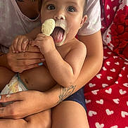 Alessio a rejoint le concours — aidez-le/la à gagner de superbes lots ! adult_hand, baby, child, close_up, cute, diaper, face, food, happy, heart_pattern, holding, ice_cream, indoor, naked_torso, person, red_blanket, sitting, skin, tattoo, tongue_out