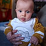 Mélina participe au concours pour gagner de l'argent avec cette photo : baby, child, infant, tongue_out, hand, clothing, sweater, indoor, person, cute, portrait, blue_eyes, face, holding, mustard_color, white_color, blurred_background, expression, cozy, casual
