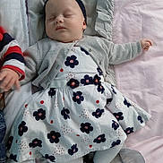 Mélina a rejoint le concours — aidez-le/la à gagner de superbes lots ! baby, sleeping, bed, blanket, dress, cardigan, headband, infant, child, cute, peaceful, indoors, soft, footwear, tights, person, rest, young, adorable, nap