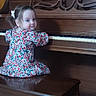 Elsie joined the competition — help win amazing prizes! bench, child, decor, face, floral_dress, furniture, hair_bow, happy, home, indoor, musical_instrument, person, piano, playful, portrait, smile, toddler, wooden_floor, wooden_piano, young_child
