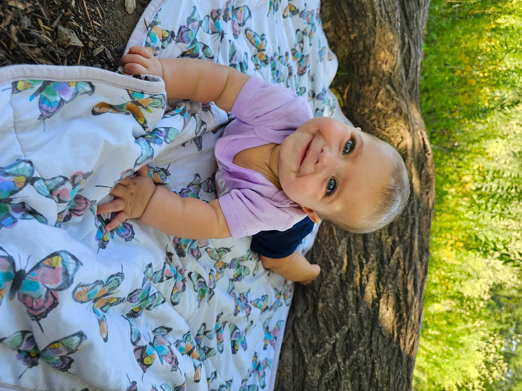 Sofia is registered to the contest to win money with this photo: child, fun, grass, happy, joy, leisure, linens, pattern, people_in_nature, person, plant, portrait_photography, recreation, sitting, sleeve, smile, spring, t_shirt, toddler, tree