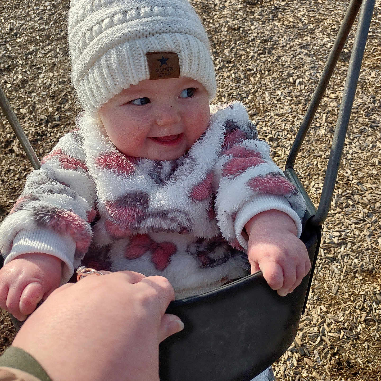 Alexis is registered to the contest to win money with this photo: baby, beanie, bodypart, bonnet, cap, clothing, coat, face, finger, hand, hat, head, outdoorplayarea, outdoors, person, photography, playarea, portrait, swing, toy