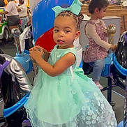 Dannylynn is registered to the contest to win money with this photo: child, toddler, girl, dress, princess_dress, carousel, amusement_park, indoor, playground, smiling, portrait, braids, hair_bow, mint_green, seated, ride, colorful, family, entertainment, photograph