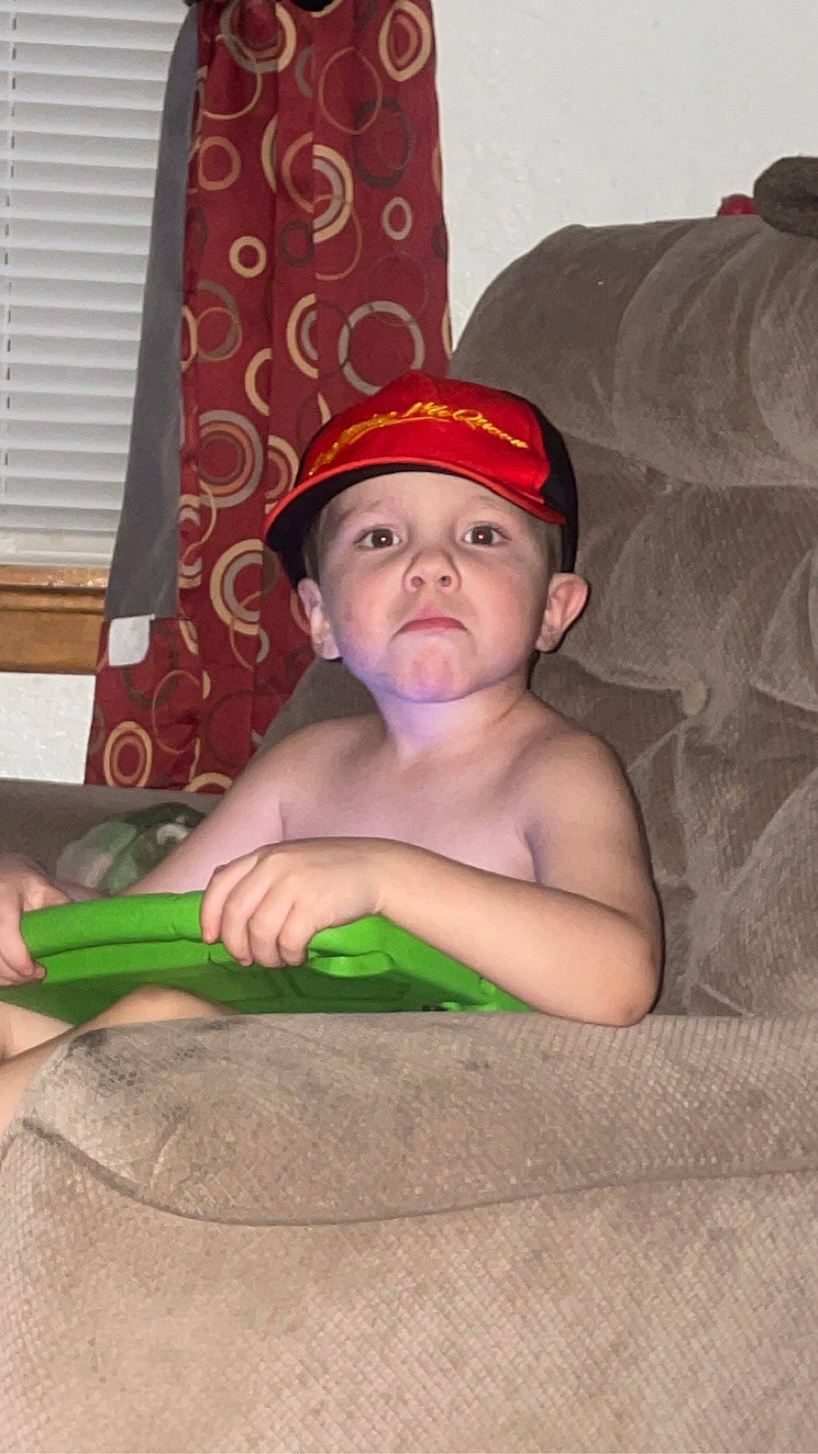 Jayse is registered to the contest to win money with this photo: baby, baby_toddler_clothing, cap, chest, child, comfort, costume_hat, curtain, eye, face, flooring, fun, head, headwear, linens, person, room, sitting, toddler, window