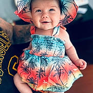 Lexi joined the competition — help win amazing prizes! baby, child, smiling, hat, colorful_clothing, tropical_pattern, toddler, portrait, indoor, person, cute, happy, summer_outfit, sitting, skin, face, headwear, bright, infant, closeup