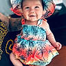 baby, child, smiling, hat, colorful_clothing, tropical_pattern, toddler, portrait, indoor, person, cute, happy, summer_outfit, sitting, skin, face, headwear, bright, infant, closeup