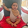baby, backyard, barefoot, bib, child, face, family_photo, folding_chair, glasses, happy, onesie, outdoor, patio, playful, portrait, red_chair, sitting, smiling, sunlight, toddler