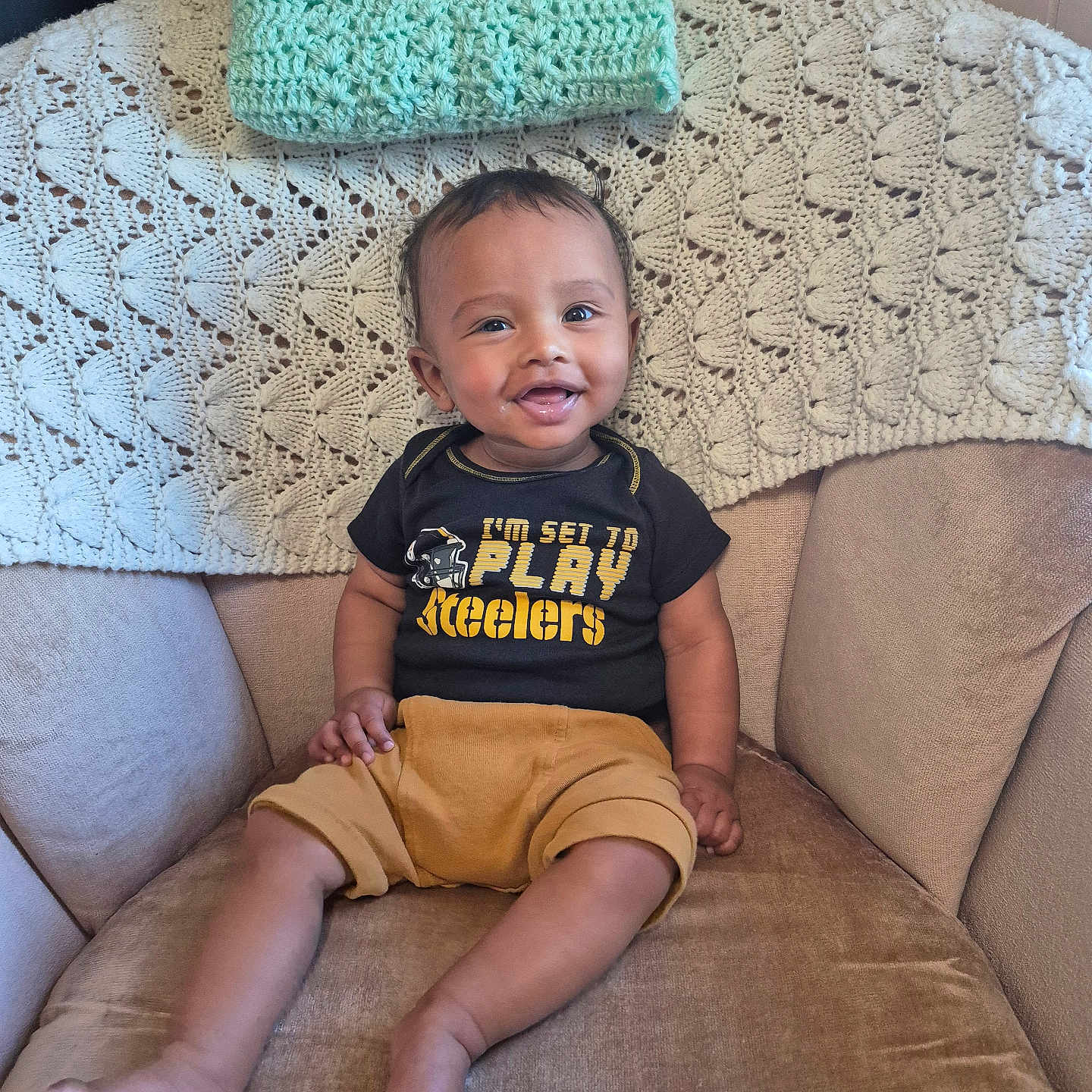 Zakariya joined the competition — help win amazing prizes! armchair, baby, blanket, child, clothing, crochet, cute, face, foot, hand, happy, home, indoor, infant, person, portrait, shirt, shorts, sitting, smiling