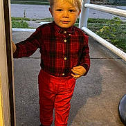 Tony is registered to the contest to win money with this photo: black_shoes, blonde_hair, building, casual_clothing, child, curious, daylight, doorway, front_view, grass, outdoor, person, plaid_shirt, portrait, red_pants, sidewalk, standing, toddler, windows, young_child