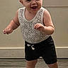 toddler, child, baby, standing, smiling, happy, laughing, blond_hair, face, portrait, indoor, home, window, wall, floor, wood_floor, tank_top, shorts, barefoot, dancing