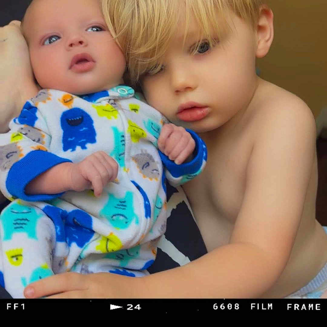Tony joined the competition — help win amazing prizes! baby, child, siblings, blond_hair, blue_eyes, portrait, cuddling, hugging, infant, toddler, pajamas, colorful_clothing, monster_pattern, family, indoor, closeup, film_frame, photography, affection, smiling