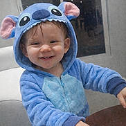 Shanna a rejoint le concours — aidez-le/la à gagner de superbes lots ! toddler, child, smiling, blue_onesie, costume, indoor, table, happy, face, hood, ears, plush, person, young_child, cute, clothing, furniture, hand, portrait, home