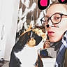 Minette a rejoint le concours — aidez-le/la à gagner de superbes lots ! cat, calico_cat, person, glasses, indoor, dreamcatcher, feathers, table, scarf, face_paint, digital_hearts, pet, cute, closeup, whiskers, love, affection, home, furniture, decor