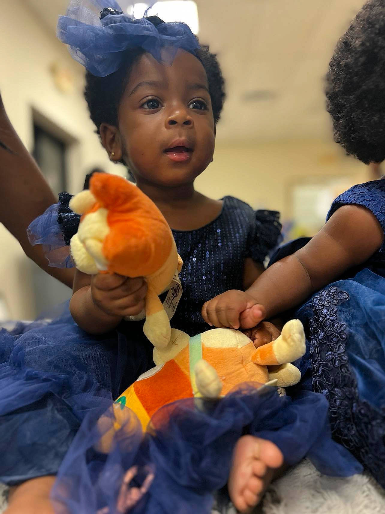 Faith joined the competition — help win amazing prizes! blue, child, event, finger, fun, gesture, happy, hat, lap, orange, organ, person, plush, room, sharing, skin, stuffed_toy, thumb, toddler, toy