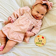 Josie joined the competition — help win amazing prizes! baby, infant, smiling, pink_dress, headband, blanket, milestone_sign, six_months, cute, happy, child, portrait, laying_down, indoor, soft_lighting, baby_girl, clothing, closeup, celebration, age_marker
