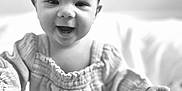 Josie joined the competition — help win amazing prizes! baby, child, smiling, headband, bow, black_and_white, portrait, happy, cute, infant, clothing, long_sleeves, person, closeup, indoors, soft_light, baby_girl, reaching_out, face, young_child