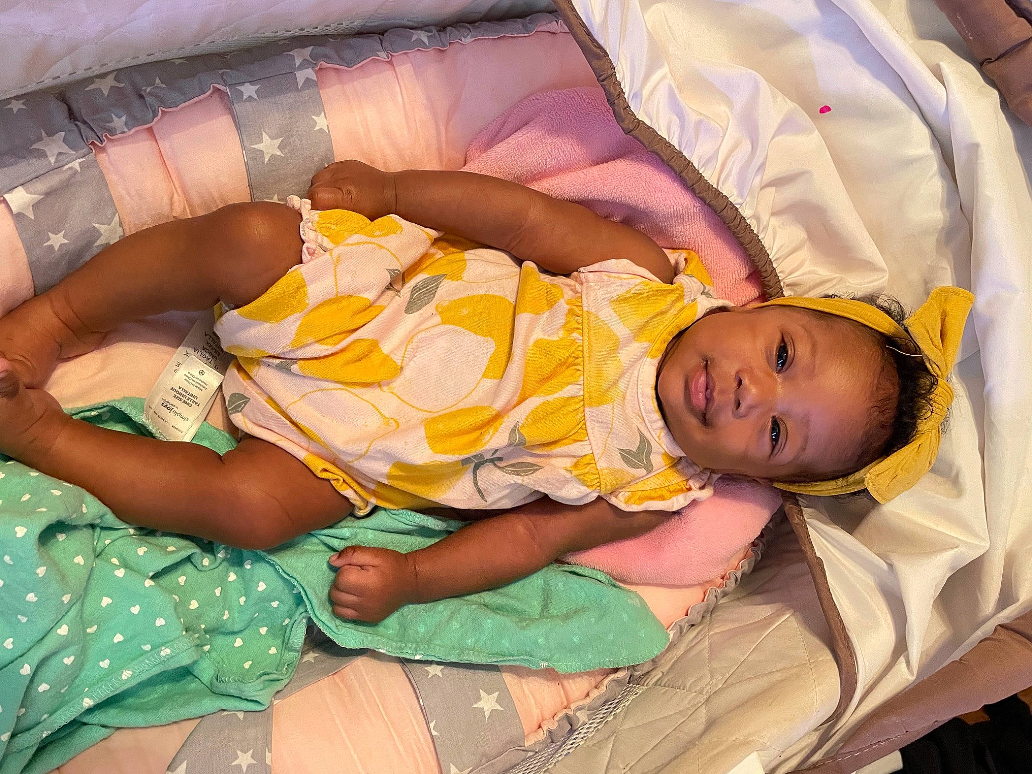 Kenzie is registered to the contest to win money with this photo: baby, baby_products, baby_toddler_clothing, child, comfort, finger, fun, happy, human_body, human_leg, lap, leg, linens, pattern, person, room, sitting, skin, textile, thigh