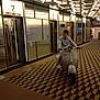 child, boy, vespa, scooter, indoor, hallway, patterned_floor, ceiling_lights, elevator, carpet, dressed_up, bow_tie, flooring, reflection, metallic_walls, waiting_area, person, transport, young, stylish