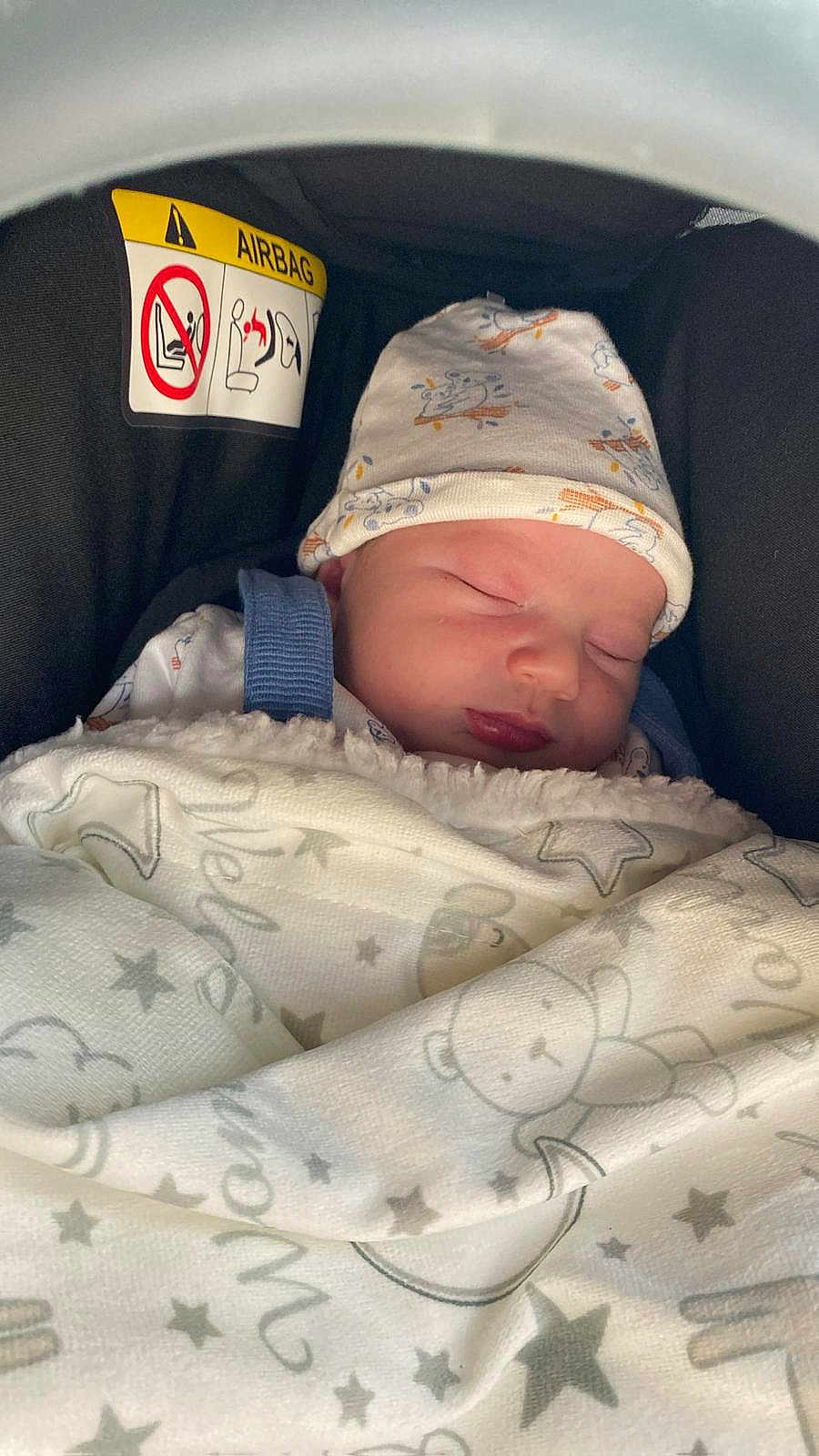 Meziane a rejoint le concours — aidez-le/la à gagner de superbes lots ! baby, newborn, sleeping, blanket, hat, car_seat, airbag_warning, infant, cozy, cute, child, face, resting, soft, wrapped, transport, safety, indoors, peaceful, portrait
