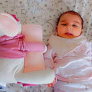 Massilya a rejoint le concours — aidez-le/la à gagner de superbes lots ! adorable, baby, bed, blanket, child, comfort, cute, face, holding_hands, indoors, infant, lying_down, pajamas, pattern, pink, sleepwear, soft_toy, stuffed_animal, white, young_child