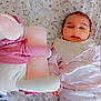 adorable, baby, bed, blanket, child, comfort, cute, face, holding_hands, indoors, infant, lying_down, pajamas, pattern, pink, sleepwear, soft_toy, stuffed_animal, white, young_child