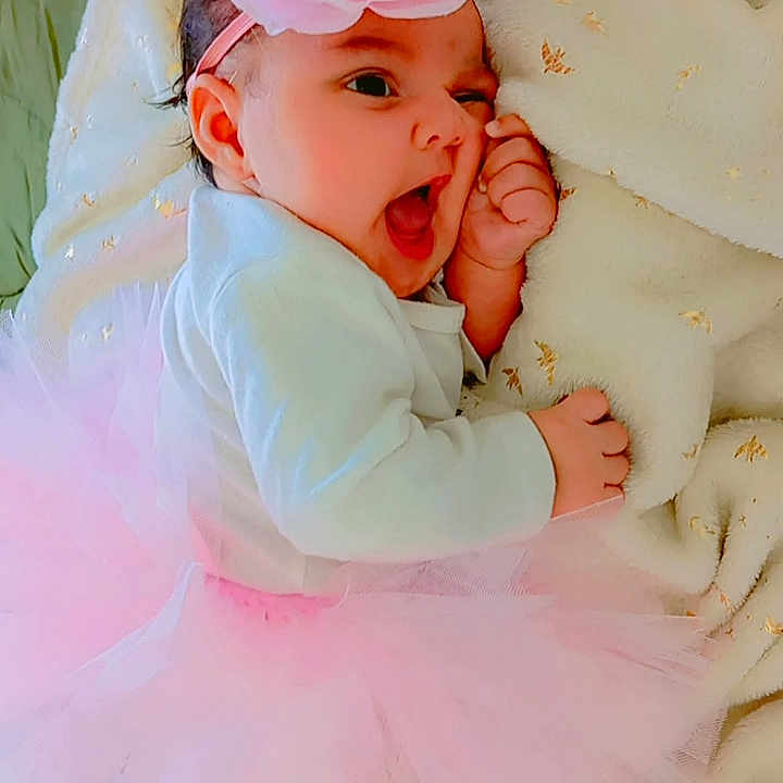 Massilya participe au concours pour gagner de l'argent avec cette photo : baby, blanket, child, clothing, cozy, cute, face, flower, giggling, hand, happy, headband, indoor, infant, pink_tutu, portrait, sleepwear, smiling, soft, toddler
