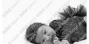 Massilya participe au concours pour gagner de l'argent avec cette photo : baby, black_and_white, infant, lying_down, headband, lace_outfit, portrait, soft_surface, watermark, cute, child, young, monochrome, small_hands, face, eyes_open, resting, studio_photo, peaceful, adorable