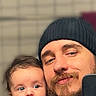 baby, man, beard, beanie, selfie, indoor, person, child, holding, portrait, casual, clothing, cute, face, headwear, smile, family, parent, infant, background