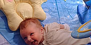 Freya is registered to the contest to win money with this photo: baby, smiling, playmat, star_pillow, toy, infant, blue, yellow, constellation_pattern, soft_toy, cute, happy, indoor, child, face, clothing, laying_down, colorful, early_childhood, playtime