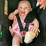 baby, car_seat, infant, child, smiling, socks, pink_dress, seatbelt, toy, happy, cute, safety_harness, indoor, closeup, person, young_child, footwear, hand, face, playful