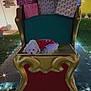 Bella is registered to the contest to win money with this photo: dog, small_dog, white_dog, festive_clothing, chair, ornate_chair, wrapped_presents, holiday_lights, nighttime, outdoor, grass, tree, decorations, festive, resting, cute, pet, holiday_season, sparkles, christmas