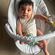 Léo participe au concours pour gagner de l'argent avec cette photo : baby, child, infant, rocker, toy, soft_toy, floor, wooden_floor, polka_dot, cute, smiling, curious, indoor, seat, clothing, person, face, hand, foot, head