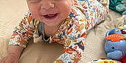 Léo a rejoint le concours — aidez-le/la à gagner de superbes lots ! baby, bed, child, closeup, colorful, cute, face, hand, happy, indoor, infant, lying_down, onesie, person, pillow, playing, smiling, soft, toddler, toy
