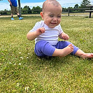 Mila is registered to the contest to win money with this photo: baby, bench, blue_vest, child, clothing, clouds, fence, foot, grass, man, nature, outdoor, park, person, phone, shorts, sitting, sky, smile, tree