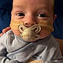 baby, infant, pacifier, medical_tape, striped_clothing, bear_patch, onesie, cute, face, child, closeup, human, newborn, portrait, indoor, person, young_child, sleepwear, hand, soft_lighting