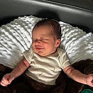 Elijah is registered to the contest to win money with this photo: baby, blanket, child, clothing, comfort, cozy, cute, human, indoors, infant, lying_down, newborn, peaceful, pillow, portrait, resting, sleeping, smiling, soft_texture, toddler