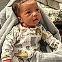 Elijah is registered to the contest to win money with this photo: baby, infant, blanket, onesie, bear_prints, curious, soft_texture, indoor, living_room, couch, carpet, child, cute, small_hands, face, head, warm, cozy, person, portrait
