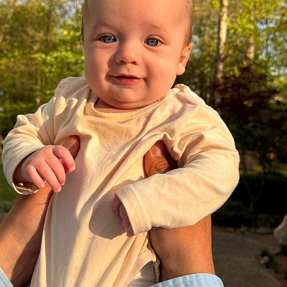Tucker joined the competition — help win amazing prizes! baby, infant, child, hands, outdoor, nature, greenery, sunlight, portrait, smile, cute, person, face, clothing, long_sleeve, skin, blue_eyes, holding, happy, daylight