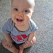 Matteo joined the competition — help win amazing prizes! baby, child, smiling, blue_eyes, sitting, carpet, tshirt, logo, happy, cute, indoor, infant, portrait, one_person, casual_clothing, barefoot, looking_up, light_skin, short_hair, playful