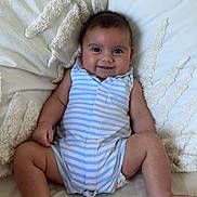 Alessio participe au concours pour gagner de l'argent avec cette photo : baby, smiling, striped_clothing, indoor, couch, pillows, plush, cute, child, infant, happy, person, sitting, skin, hand, foot, face, head, comfort, relaxation