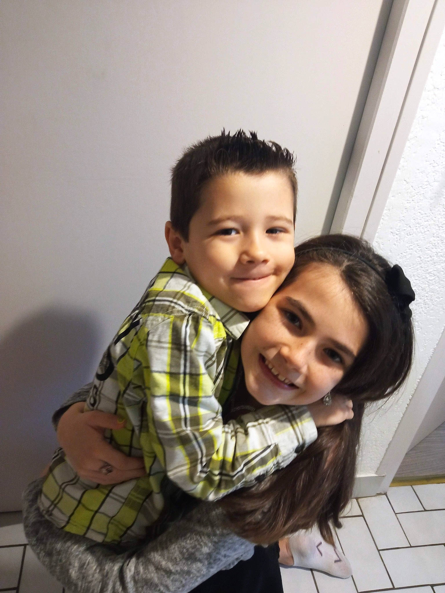 Elsa a rejoint le concours — aidez-le/la à gagner de superbes lots ! black_hair, child, eye, face, flash_photography, flooring, fun, gesture, happy, iris, joy, nose, person, plaid, sitting, skin, sleeve, smile, standing, tartan