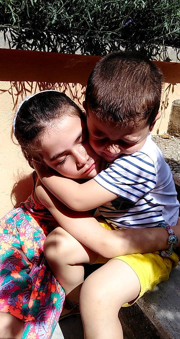 Elsa participe au concours pour gagner de l'argent avec cette photo : child, cool, friendship, fun, gesture, grass, hairstyle, happy, human_leg, leisure, mouth, people_in_nature, person, red, shorts, shoulder, sitting, skin, smile, thigh