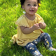 Kaylani joined the competition — help win amazing prizes! toddler, child, grass, outdoor, yellow_top, floral_leggings, curly_hair, flower, dandelion, smiling, sunlight, nature, happy, cute, sitting, greenery, baby, casual_clothing, daylight, portrait