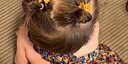 Mélya participe au concours pour gagner de l'argent avec cette photo : child, hair, hair_bun, hair_accessory, yellow_flower, dress, floral_pattern, colorful_clothing, sitting, top_view, brown_hair, childrens_fashion, indoors, textured_surface, patterned_fabric, cute, young_child, hairstyle, flower_clip, skin