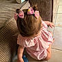 toddler, child, pink_bows, pink_dress, hair, sitting, floor, tile_floor, couch, curious, indoor, baby, person, top_view, hair_accessories, young_child, cute, small, childhood, furniture