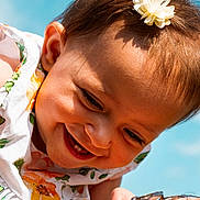 Mathilde participe au concours pour gagner de l'argent avec cette photo : baby, child, smiling, face, flower, headband, dress, floral, outdoor, blue_sky, sunlight, happy, closeup, portrait, skin, hair, person, cute, infant, joy