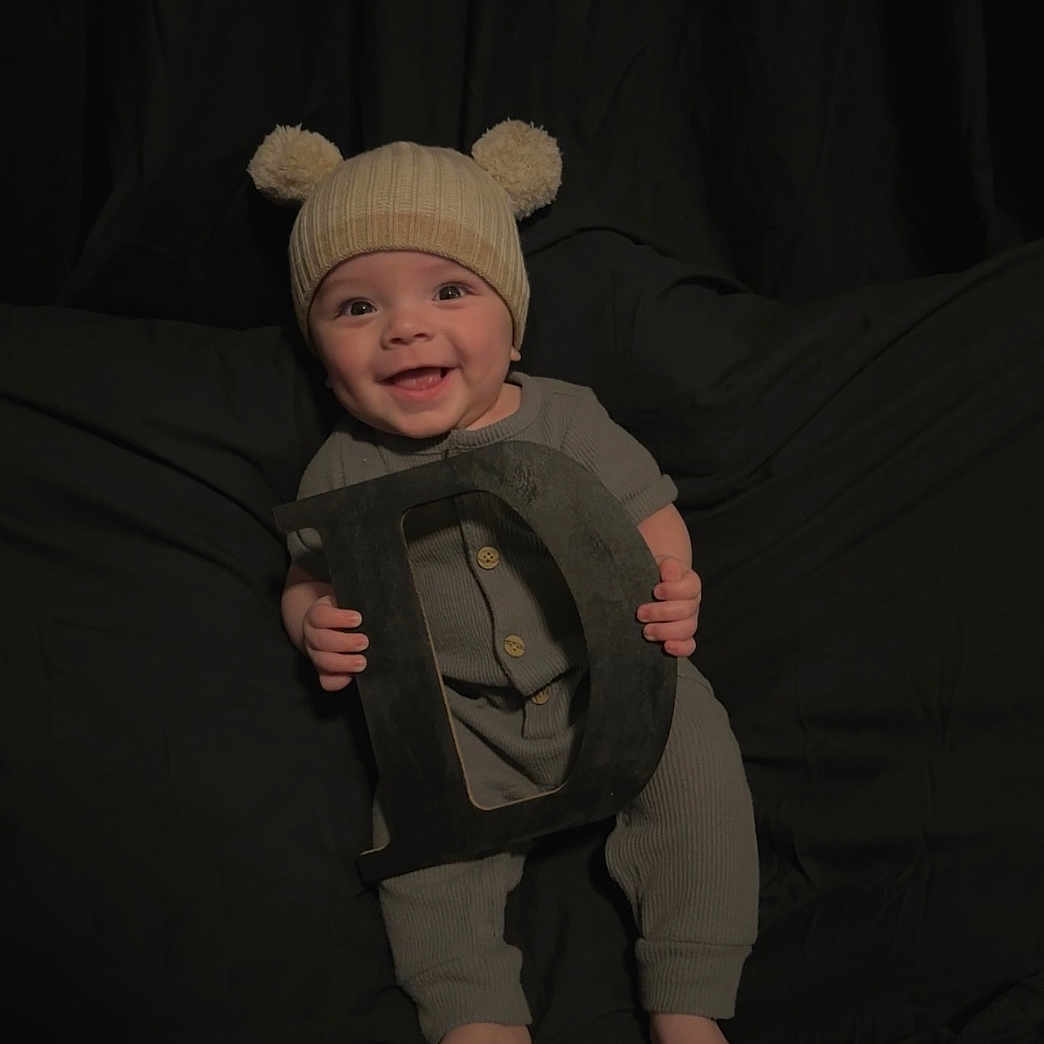 Ezra joined the competition — help win amazing prizes! baby, bodypart, bonnet, cap, clothing, face, finger, glove, hand, happy, hat, head, hood, laughing, pants, person, photography, portrait, sitting, smile